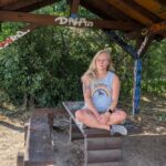 blonde frau sitzt im Schneidersitz auf Bank Routine