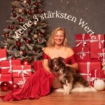 Blonde Frau mit braunem Hund vor weihnachtliochen Hintergrund, Symbolbild für Werte
