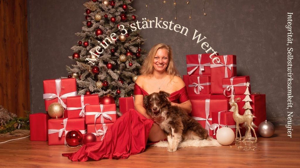 Blonde Frau mit braunem Hund vor weihnachtliochen Hintergrund, Symbolbild für Werte