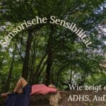 Frau liegt auf Bank in Wald, Symbolbild für Reizüberflutung und sensorische Überlastung