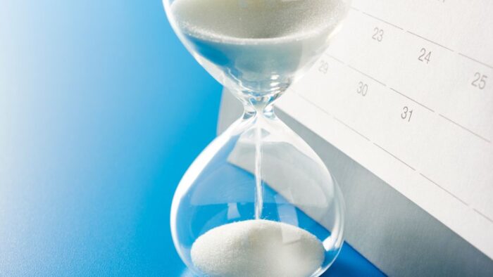 Bild einer Sanduhr vor einem Kalender