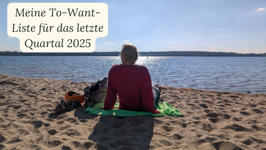 Blonde Frau sitzt an Seestrand und schaut in die Ferne, Ansicht von hinten