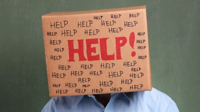 Mensch mit Papiertüte auf dem kopf, auf der "Help!" steht