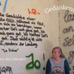Frau sitzt vor Wand die mit Graffitti beschrieben ist, im Text "Gedankenspiralen stoppen ADHS - die 3 Siebe des Sokrates"